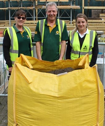 3 Rolawn team members stand behind a bulk bag of soil