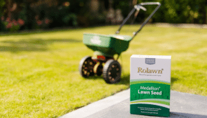 Box of Rolawn Medallion Lawn Seed with spreader in background