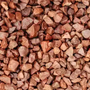 Close up of red granite 20mm gravel chippings while wet.